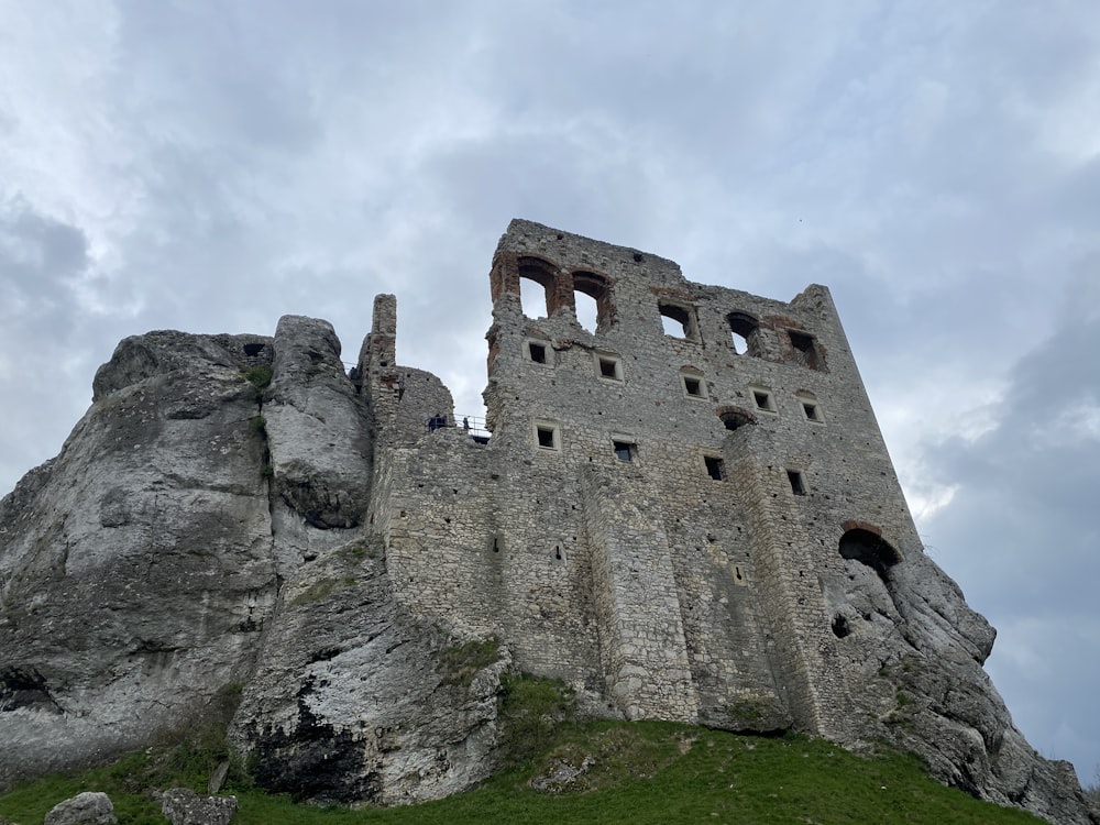 a large stone castle sitting on top of a lush green hillside