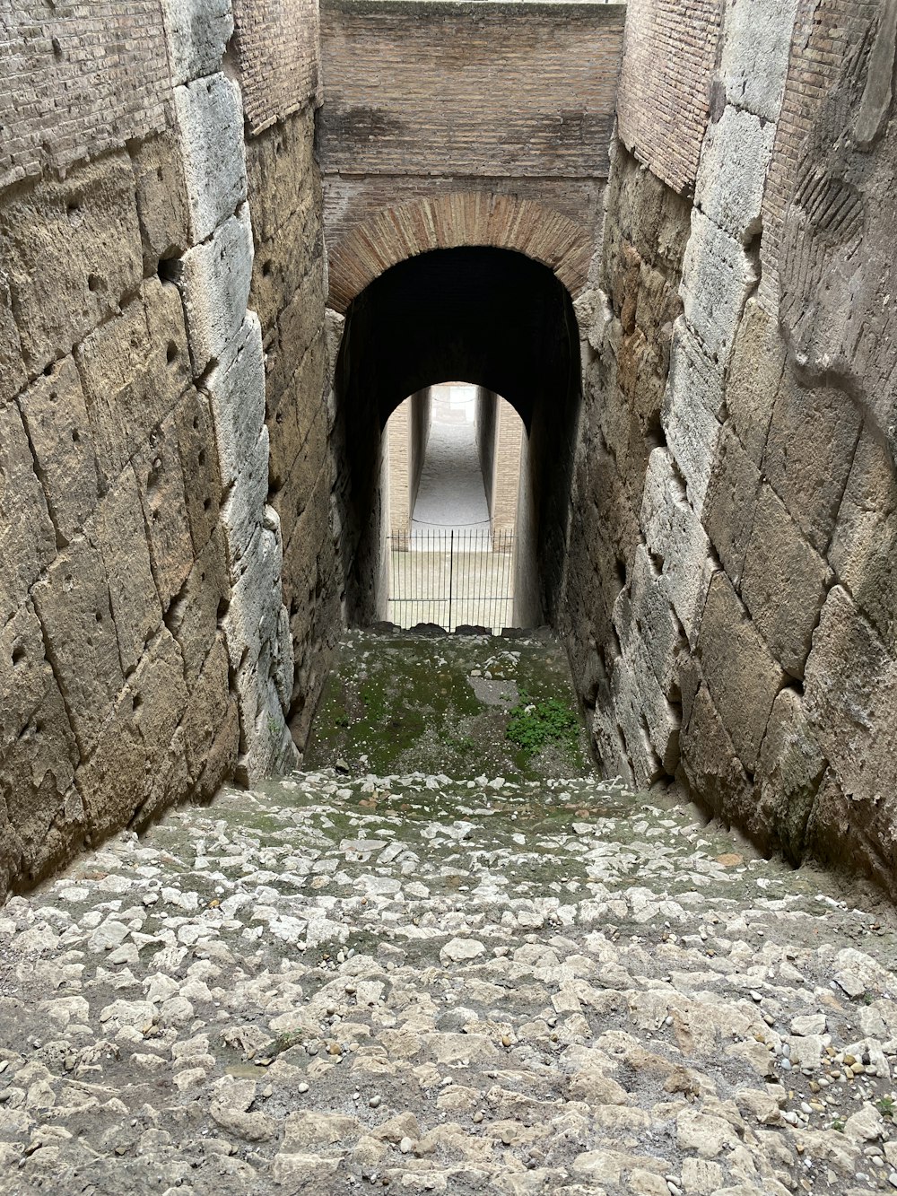 a stone tunnel with a walkway going through it