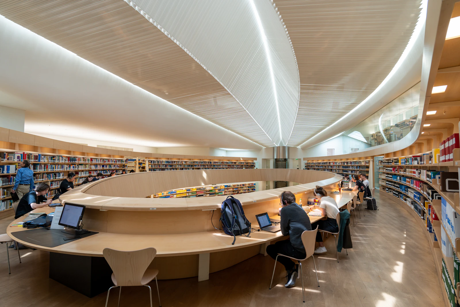 Students working at tables in a large library