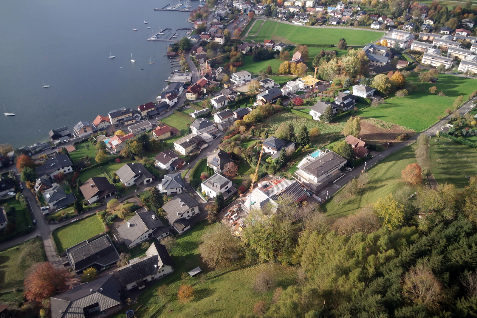 Photograph of Aerial view of Gmunden's lakeside neighbourhoods, green fields and the blue edge of Traunsee.