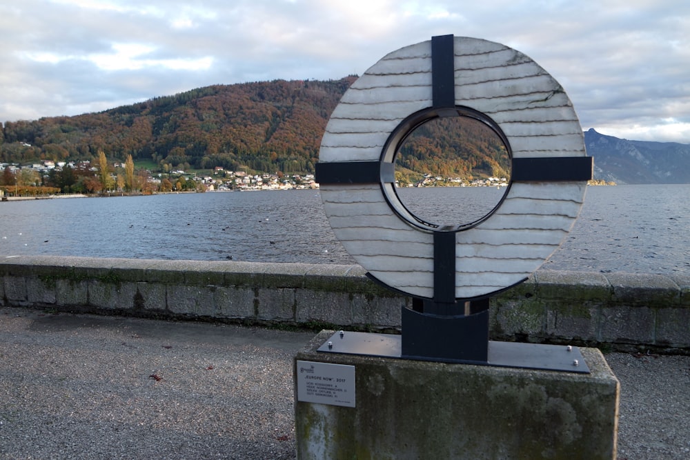 Una scultura sul lato di una strada vicino a uno specchio d'acqua