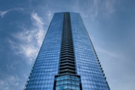 A sleek skyscraper reflecting blue skies, symbolizing economic growth.