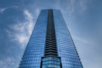 A sleek skyscraper reflecting blue skies, symbolizing economic growth.