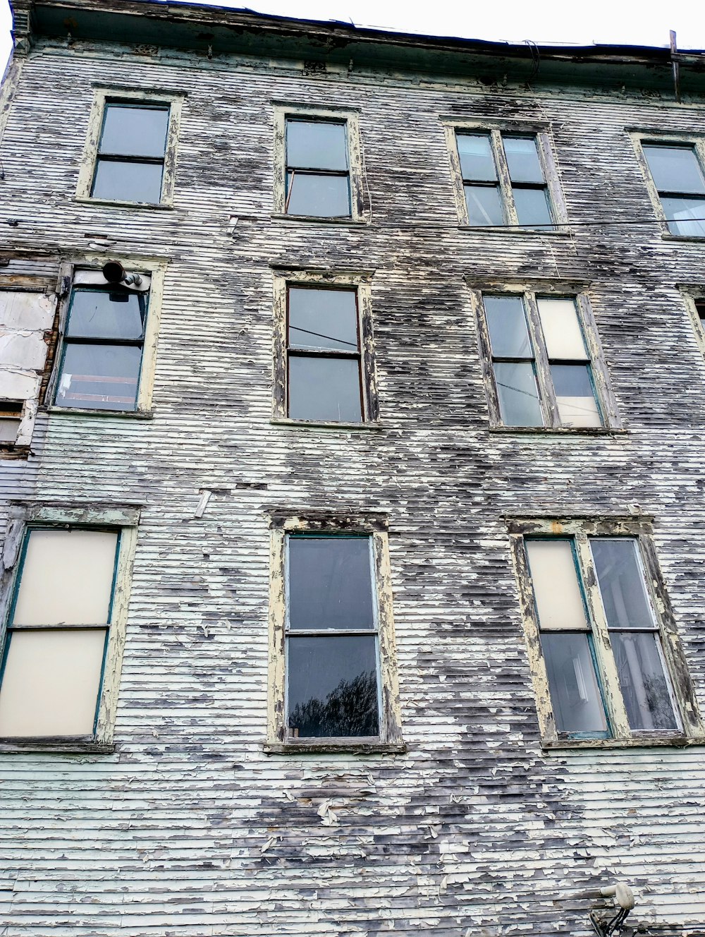 an old brick building with several windows and a clock on the side of it