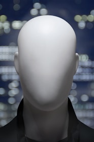 a white mannequin's head in front of a cityscape