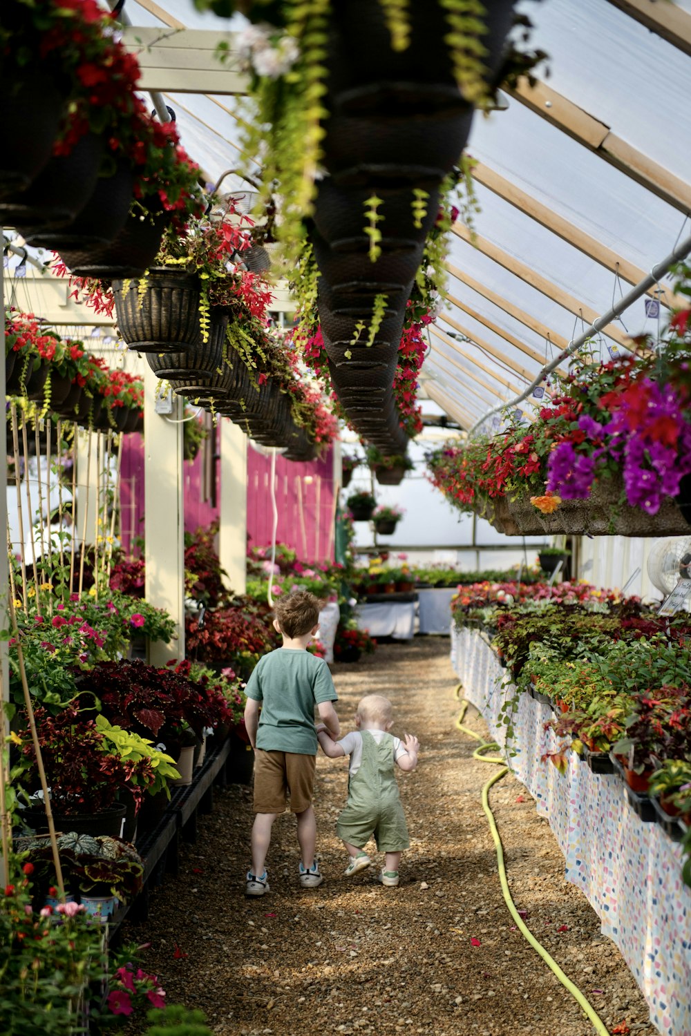 a woman and a child walking through a greenhouse