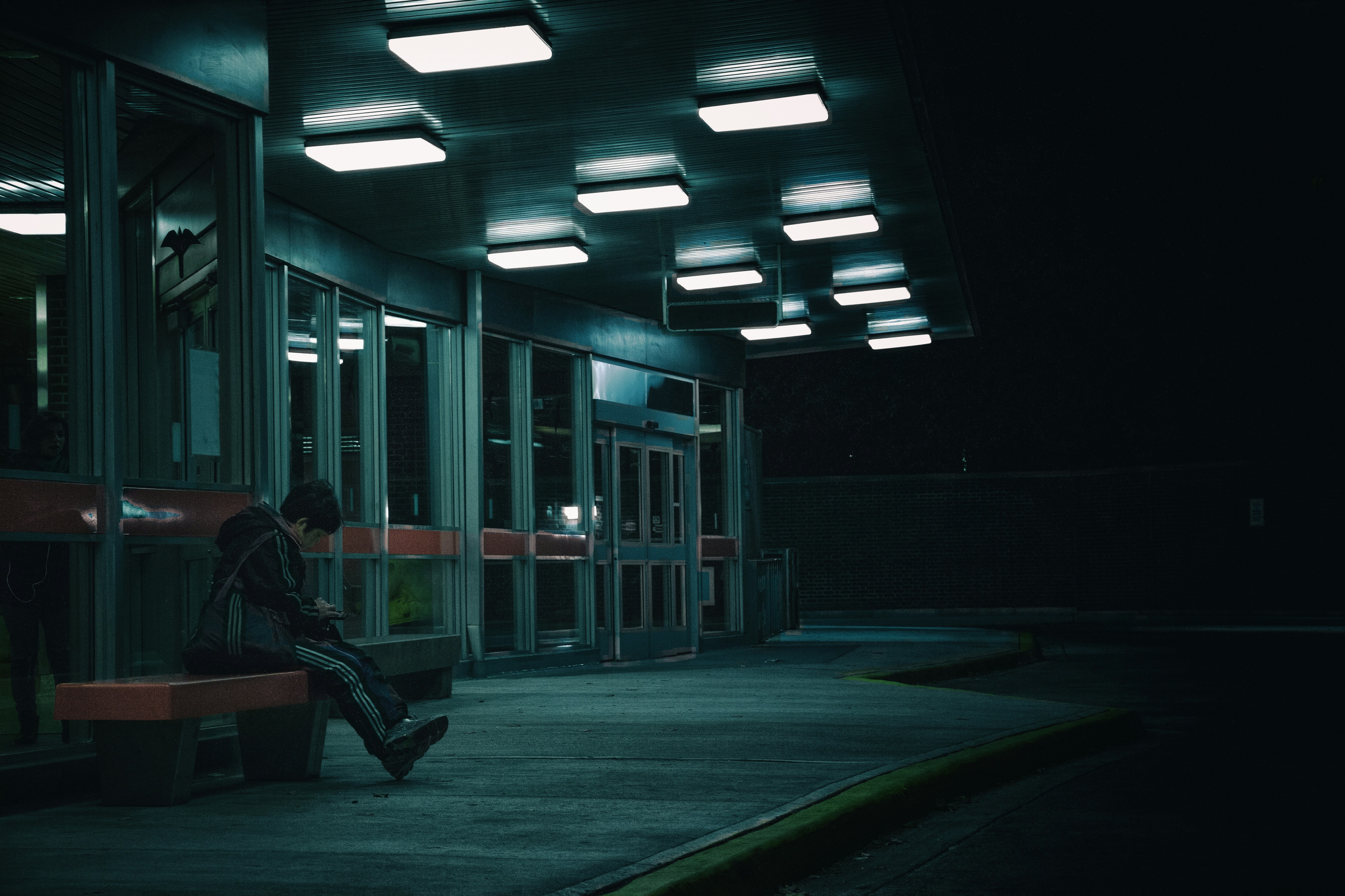 a person sitting on a bench at night
