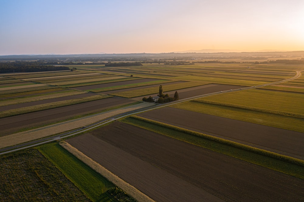 an aerial view of a farm field at sunset