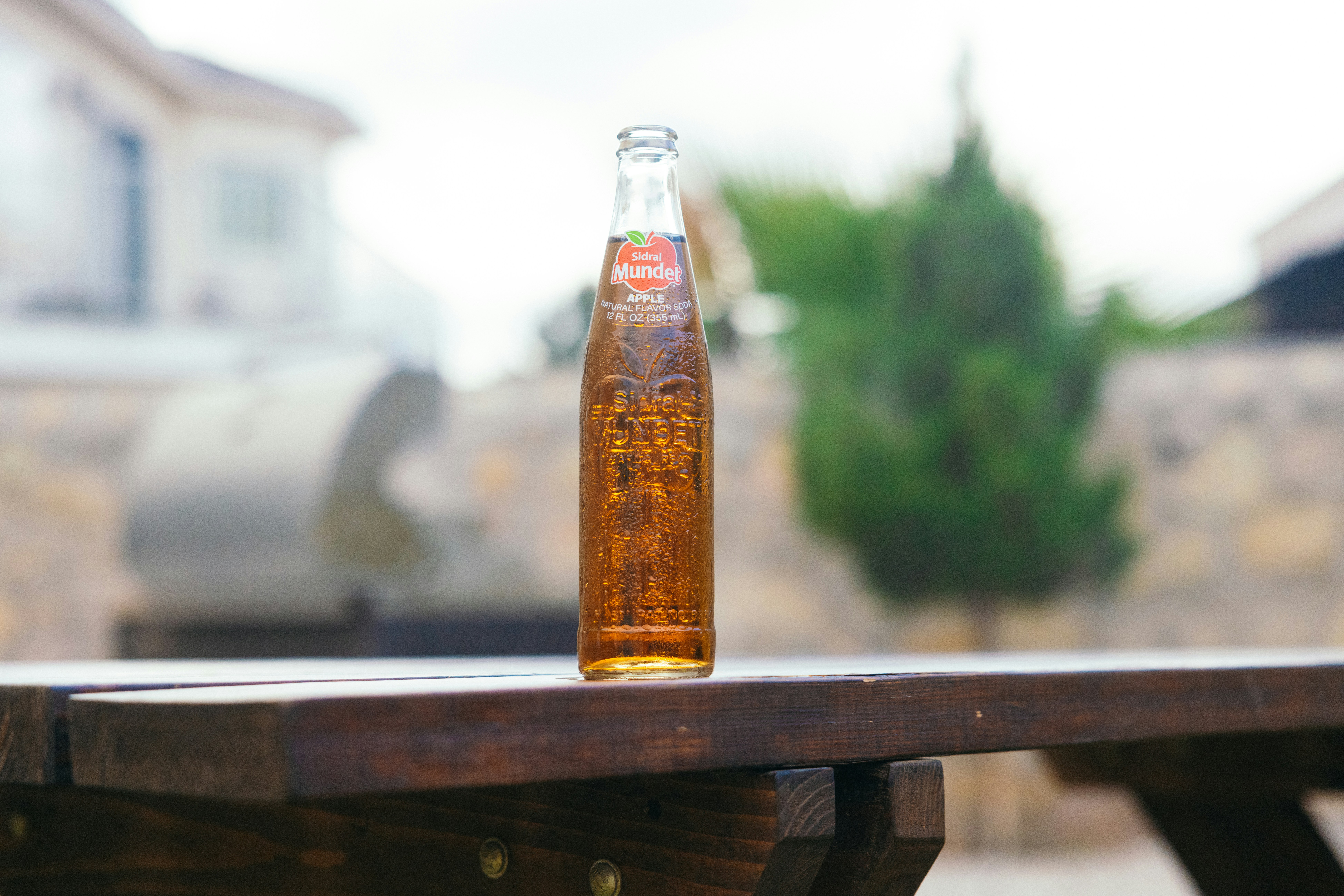 a bottle of beer sitting on top of a wooden table