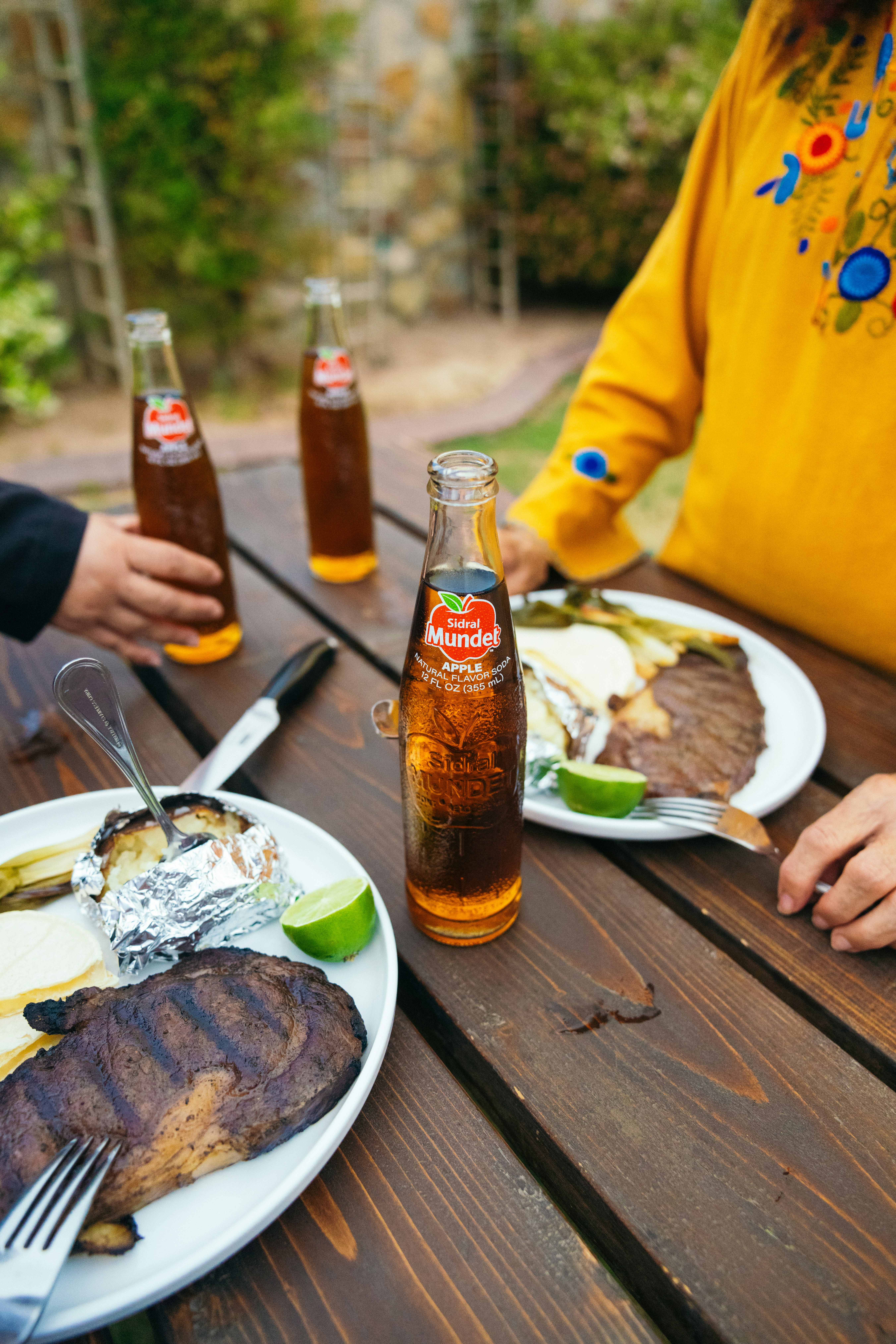 a couple of people sitting at a table with plates of food