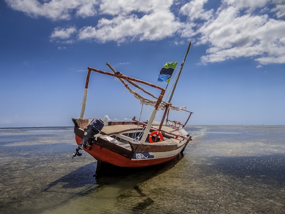 a boat sitting on top of a sandy beach