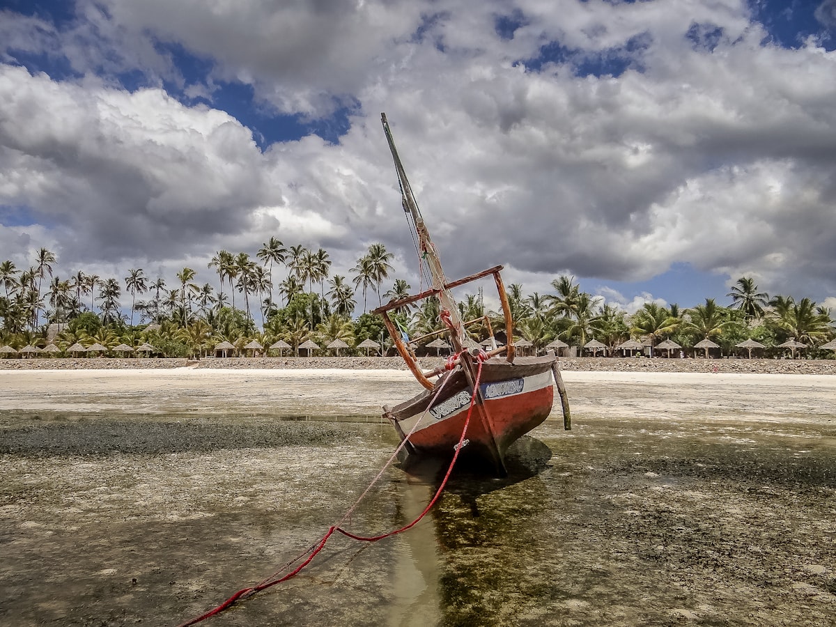 Zanzibar May — traditional dhow sailboat resting on a quiet beach at the end of the long rains season