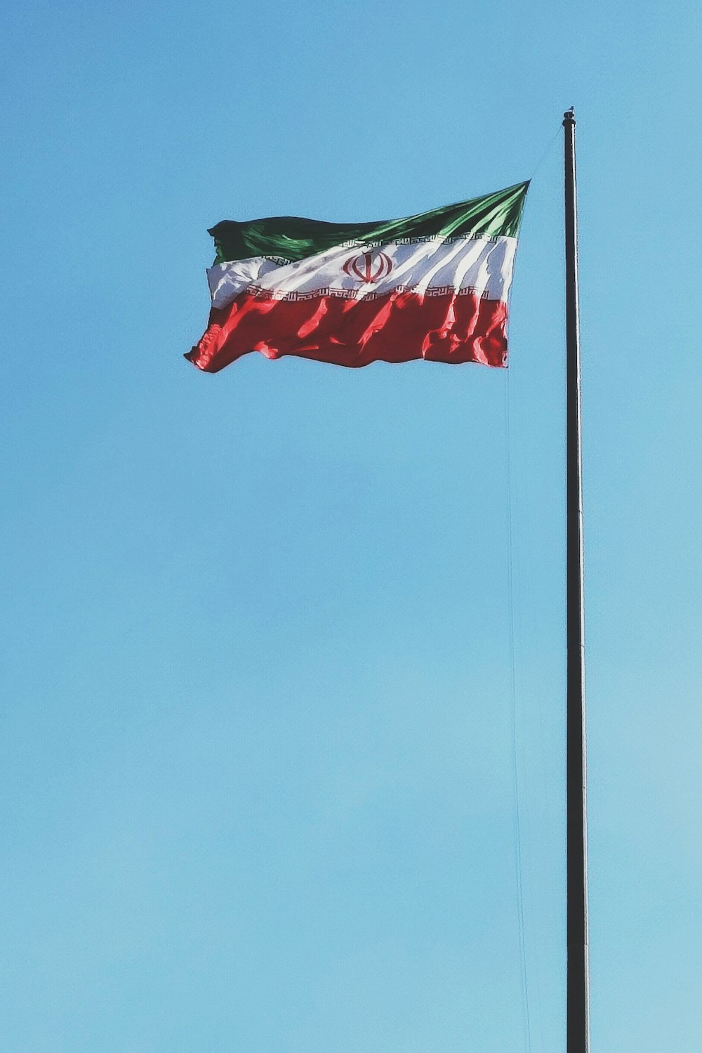 a flag flying in the wind on a flag pole