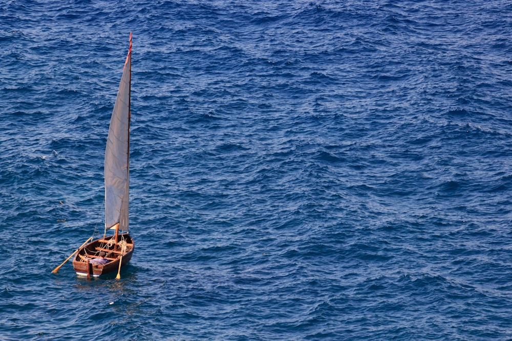 a small sailboat floating on top of a large body of water