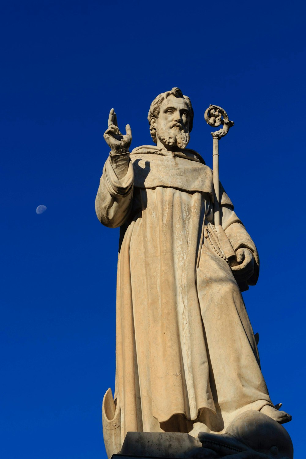 a statue of a man with a staff in his hand