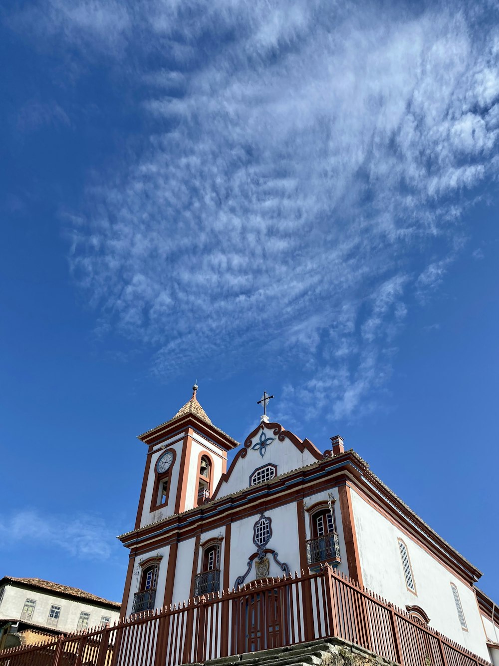 um edifício branco e marrom com uma cruz no topo