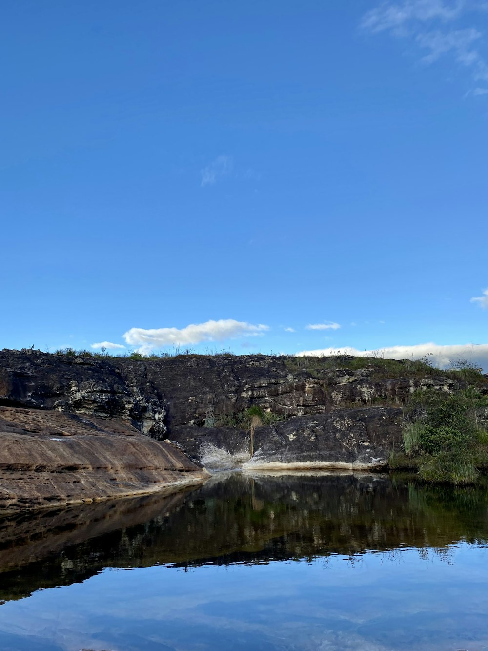 a large body of water surrounded by a rocky cliff