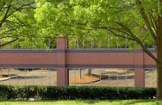 Renovated brick building featuring modern glass additions and landscaped surroundings.