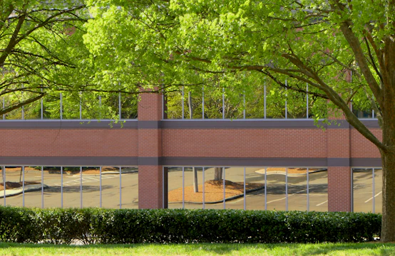 Renovated brick building featuring modern glass additions and landscaped surroundings.