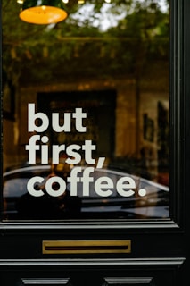 a sign on a door that says but first coffee