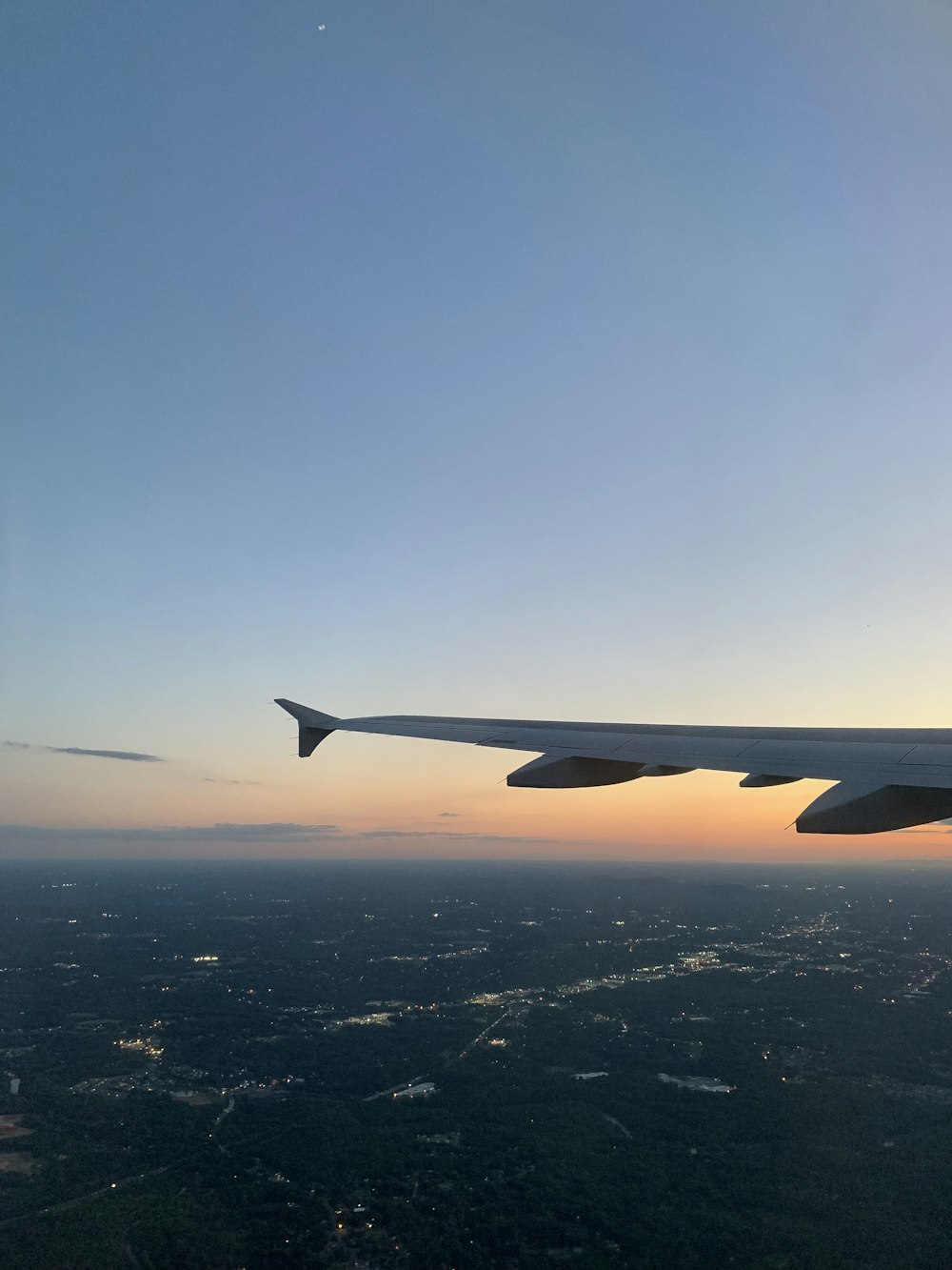 the wing of an airplane flying over a city