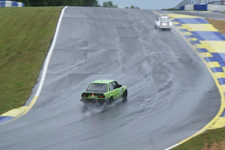 a green car driving down a race track