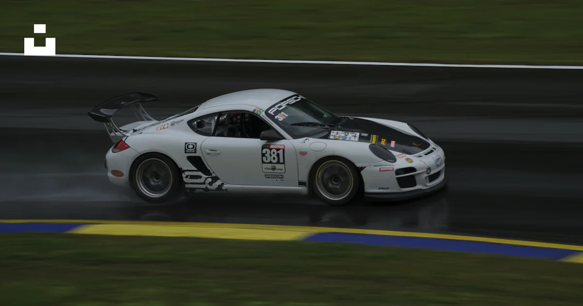 A white sports car driving on a wet track photo – Free Porshce Image on ...
