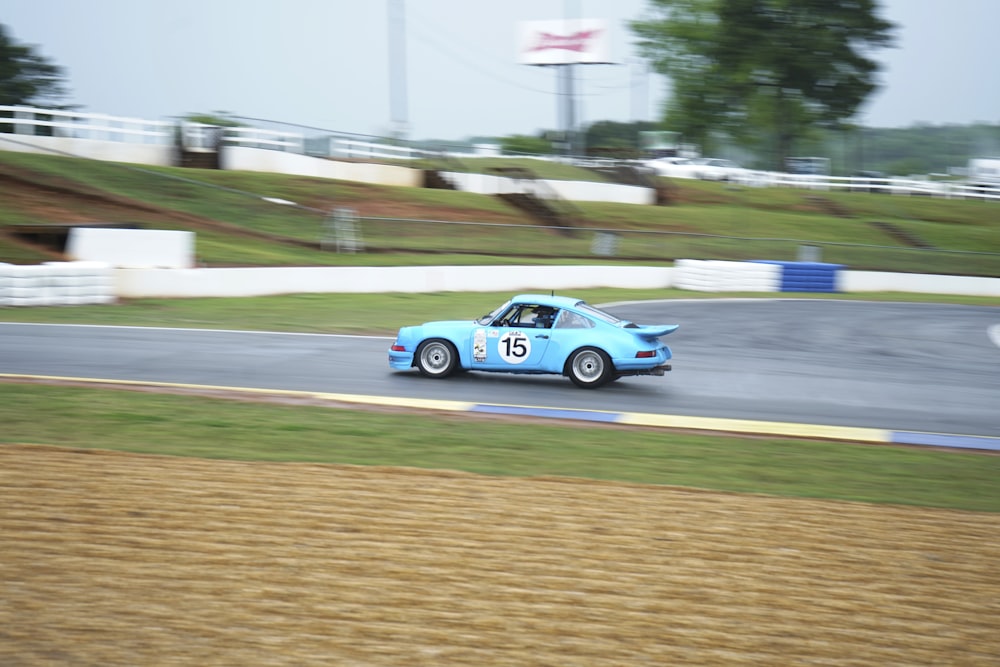 a blue car driving down a race track