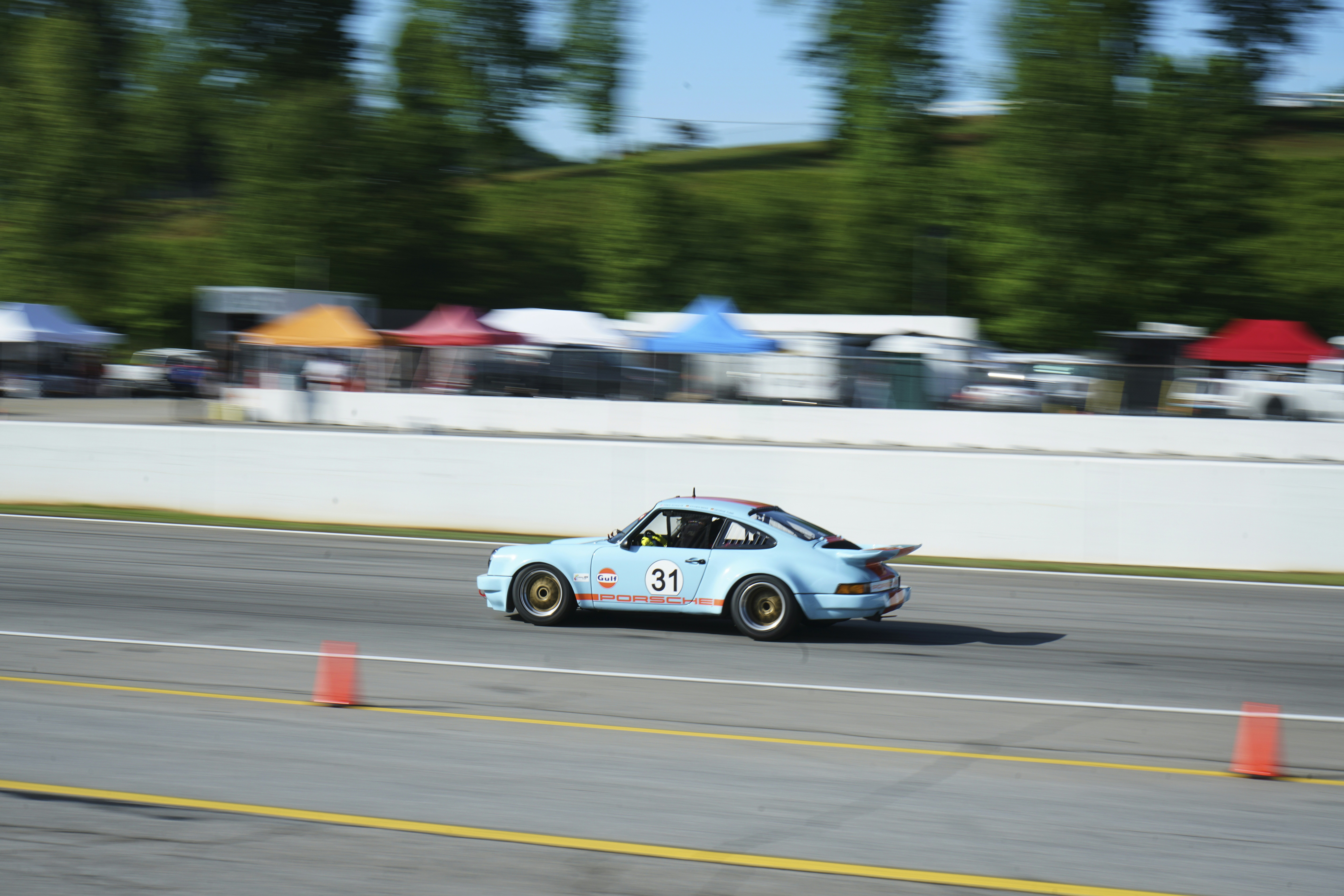 a blue car driving down a race track