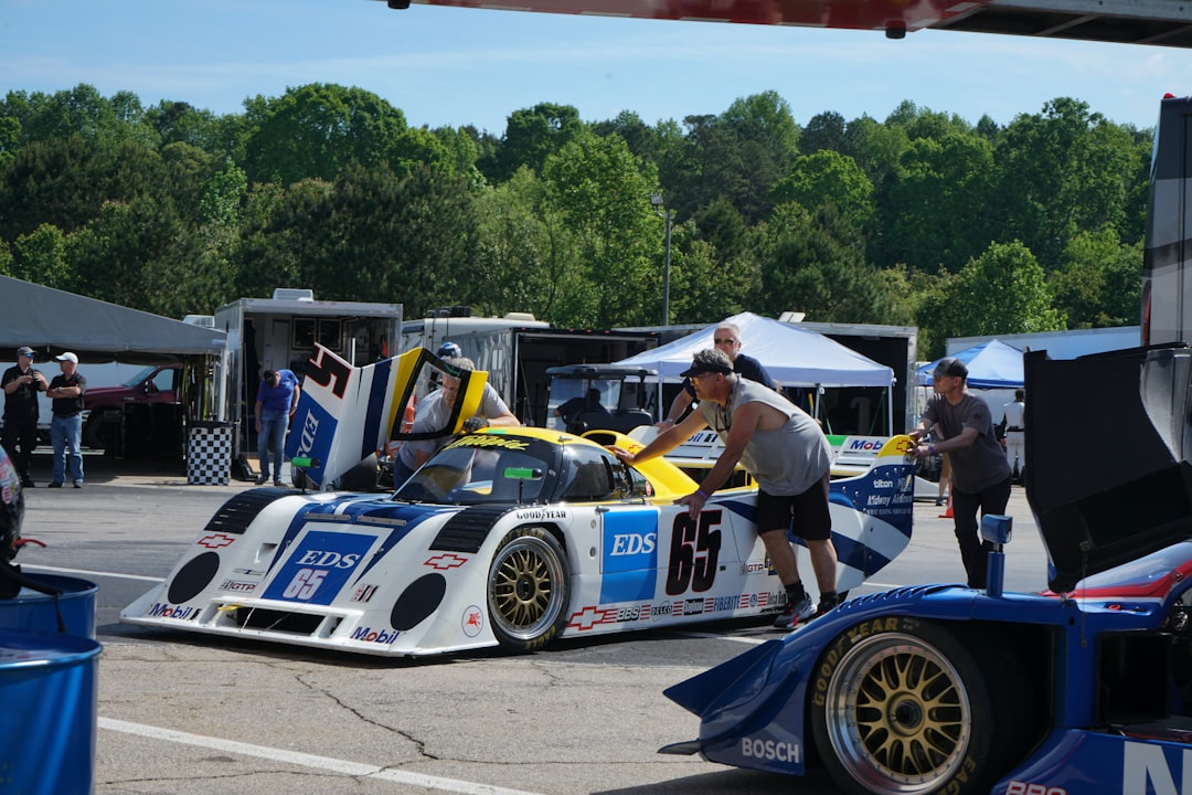 Racing cars in the paddock being pushed by mechanics - Castle Combe Race Circuit, North Wiltshire, UK – Photo by Jaxon Smith | Castle Combe England