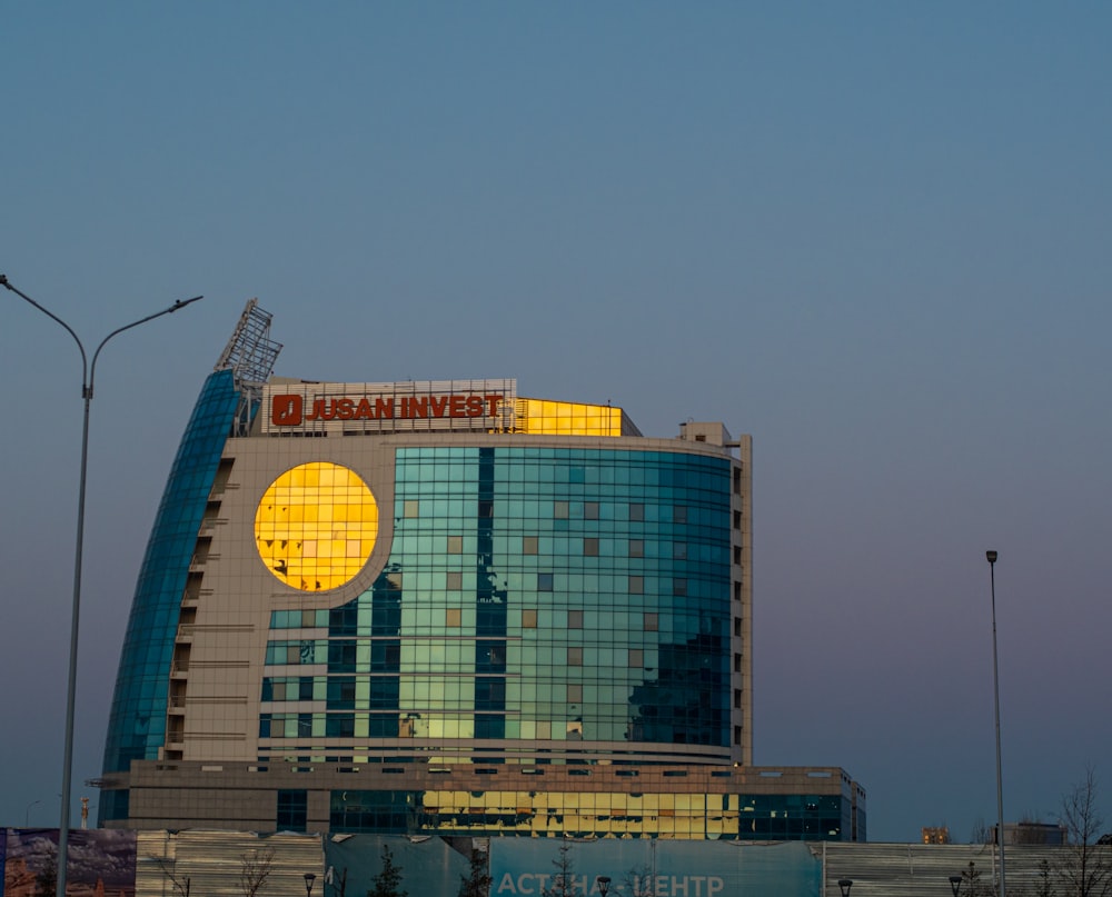 a tall building with a giant round sign on top of it