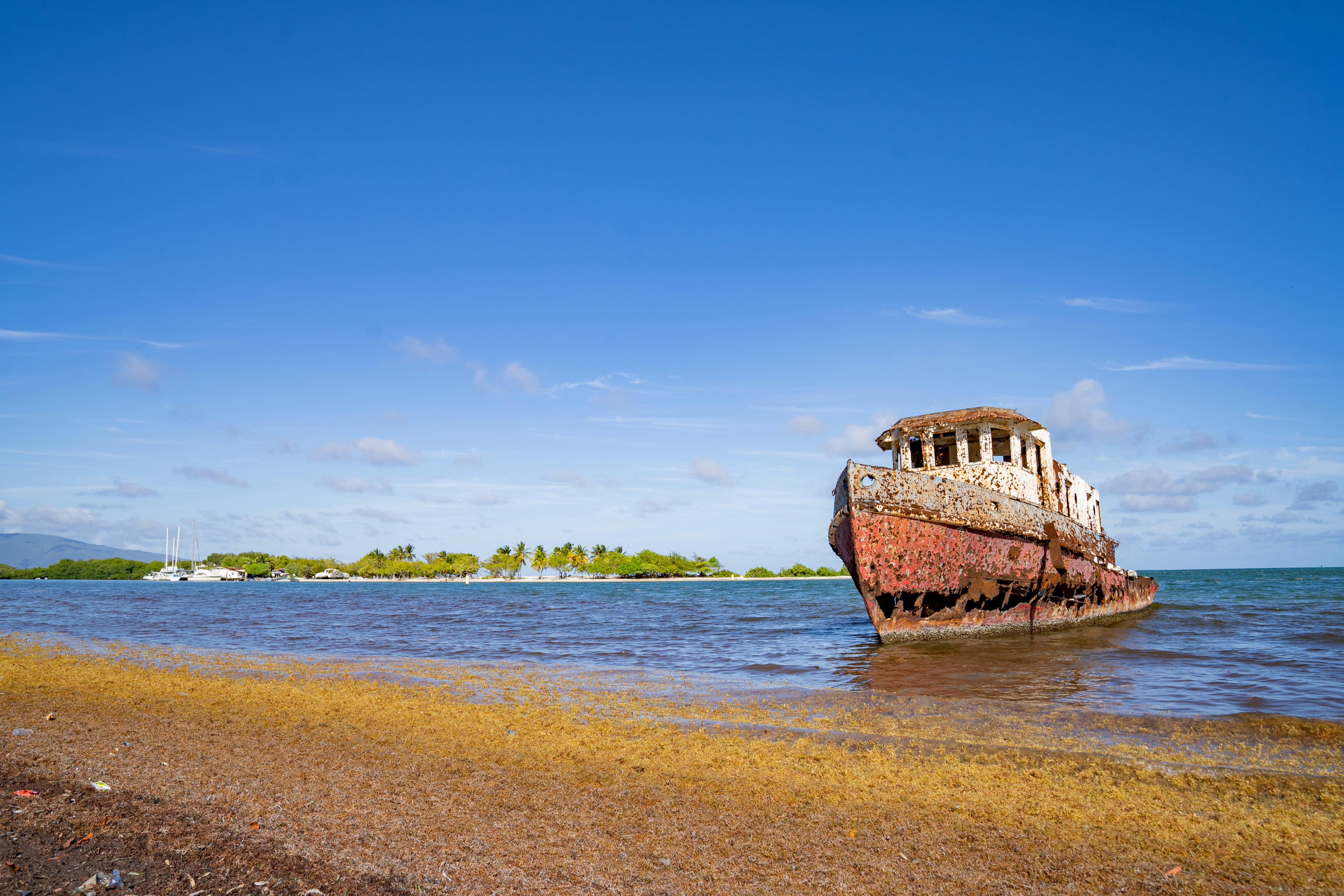 An old boat sitting on top of a sandy beach photo – Free Dominican ...
