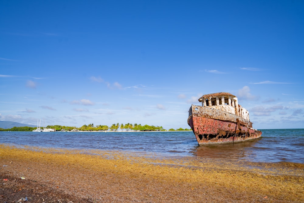 an old boat sitting on top of a sandy beach