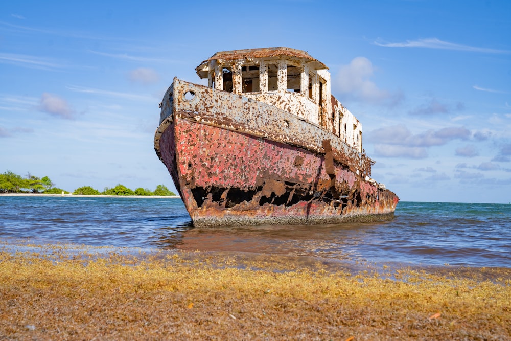 an old rusted boat sitting on top of a beach