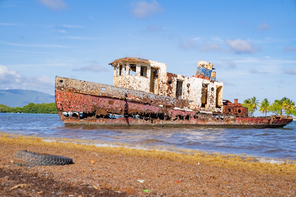 an old rusted boat sitting on top of a beach