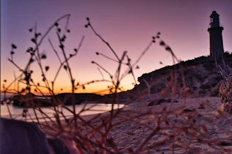 a light house sitting on top of a sandy beach