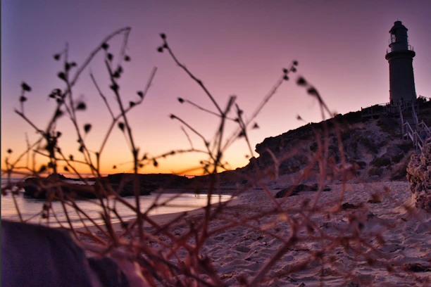 a light house sitting on top of a sandy beach