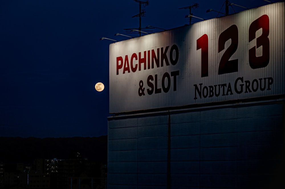 a full moon is seen behind a sign