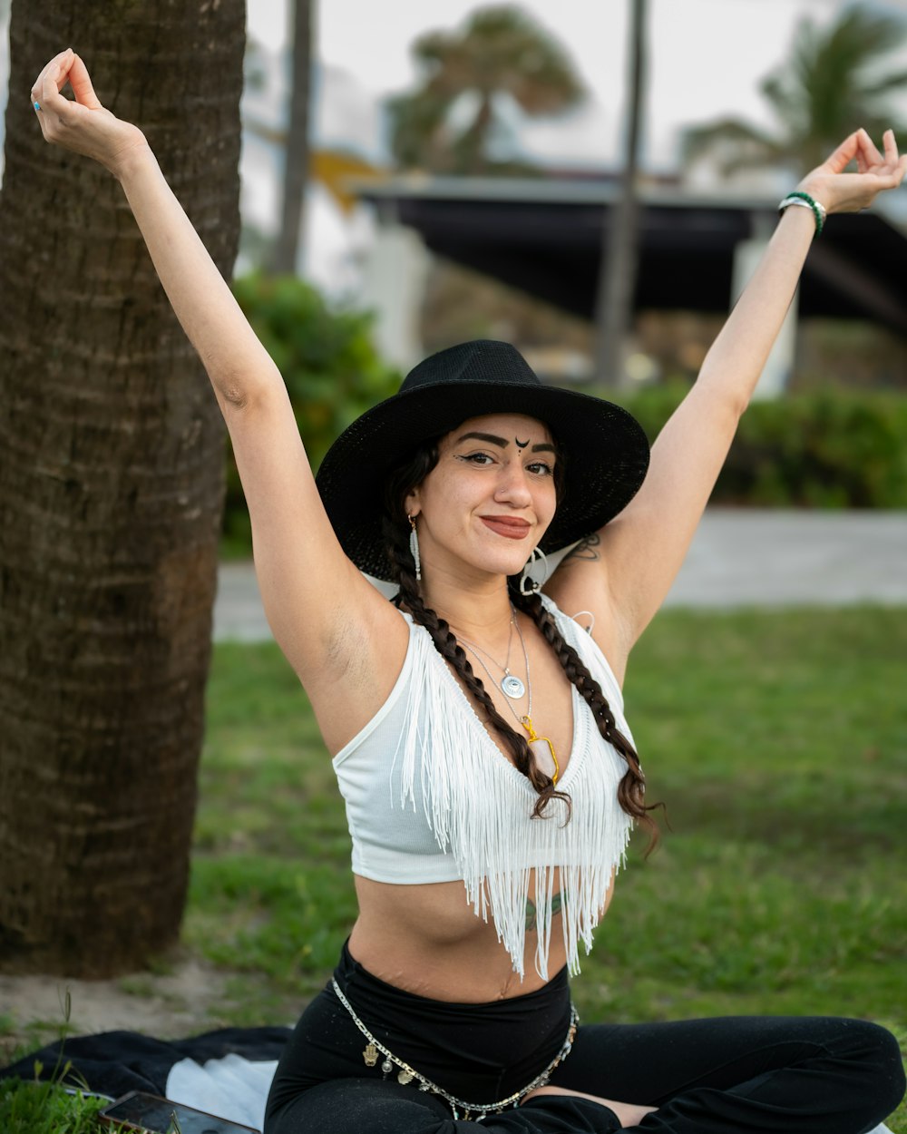 a woman sitting on the ground with her arms in the air