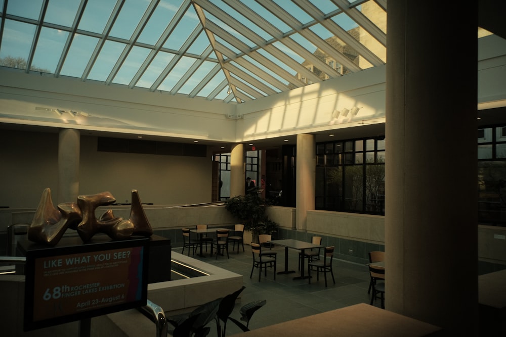 a room with a glass roof and tables and chairs