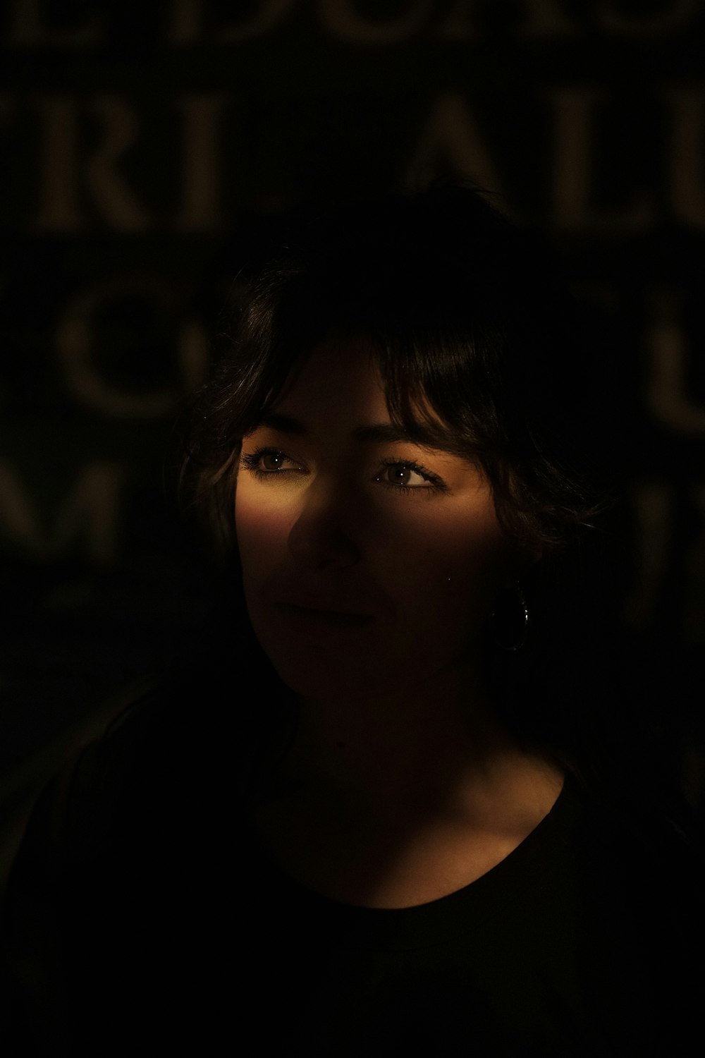 a woman in a dark room with a dark background