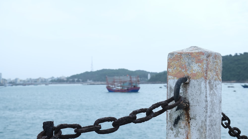 a boat is in the water behind a chain