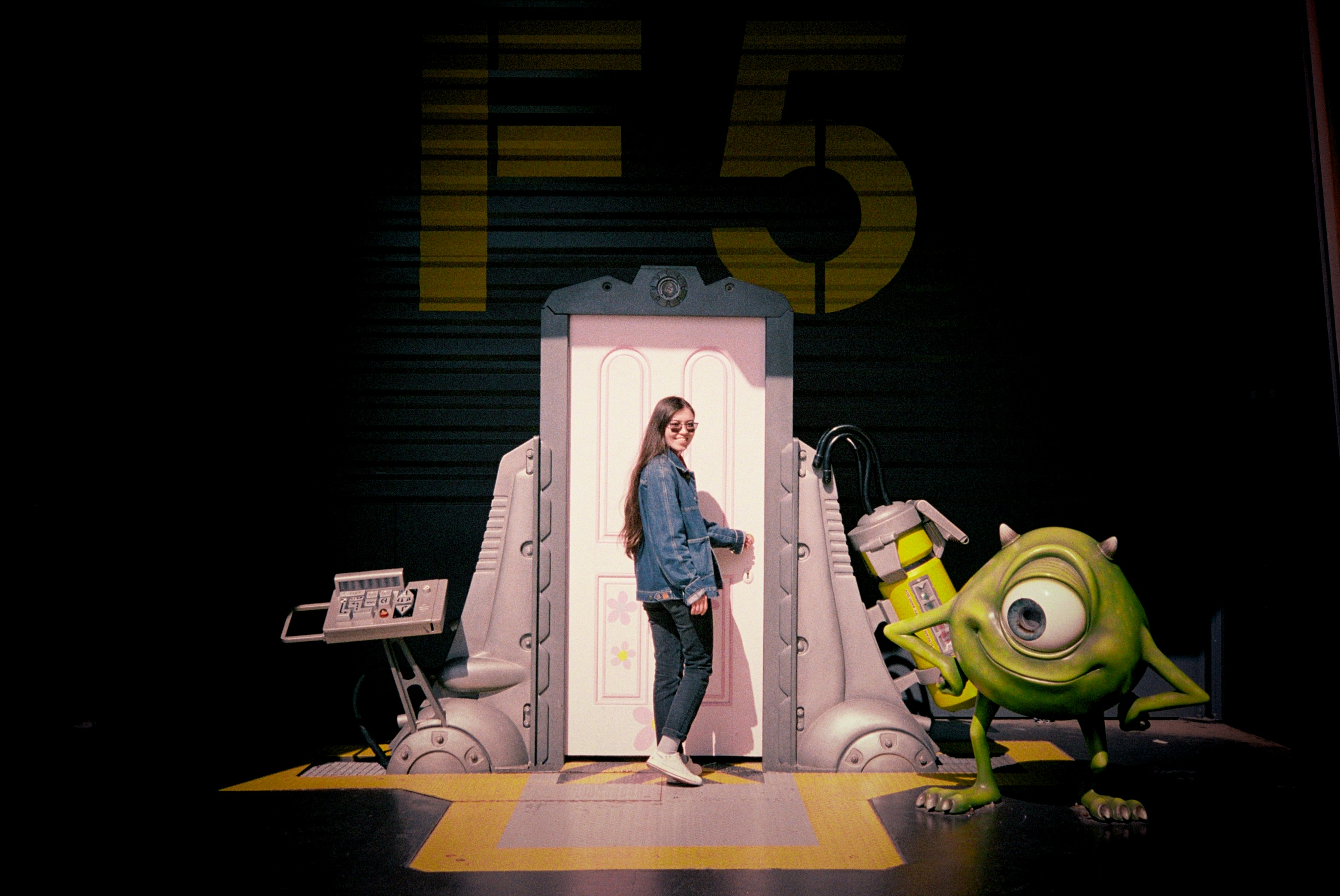 A woman standing in front of a doorway next to a green monster photo ...