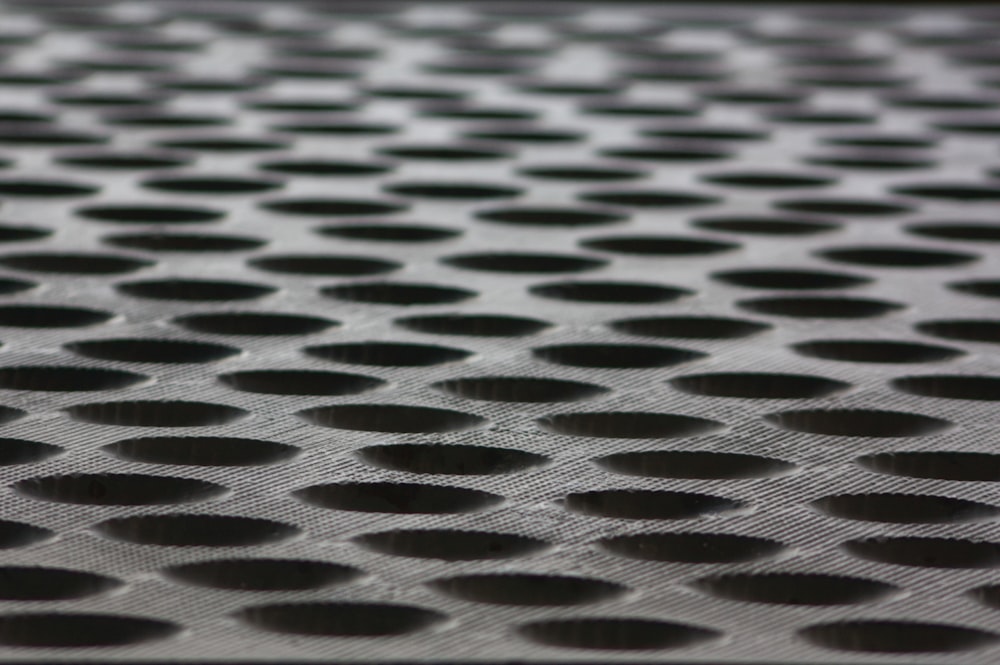a close up of a metal surface with holes