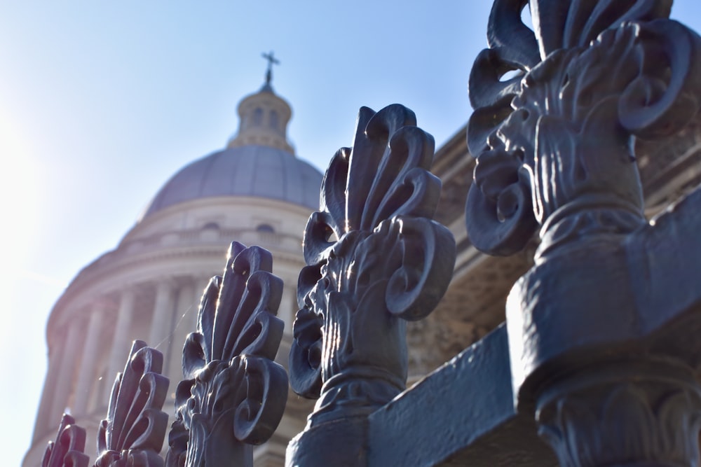 a close up of a fence with a building in the background