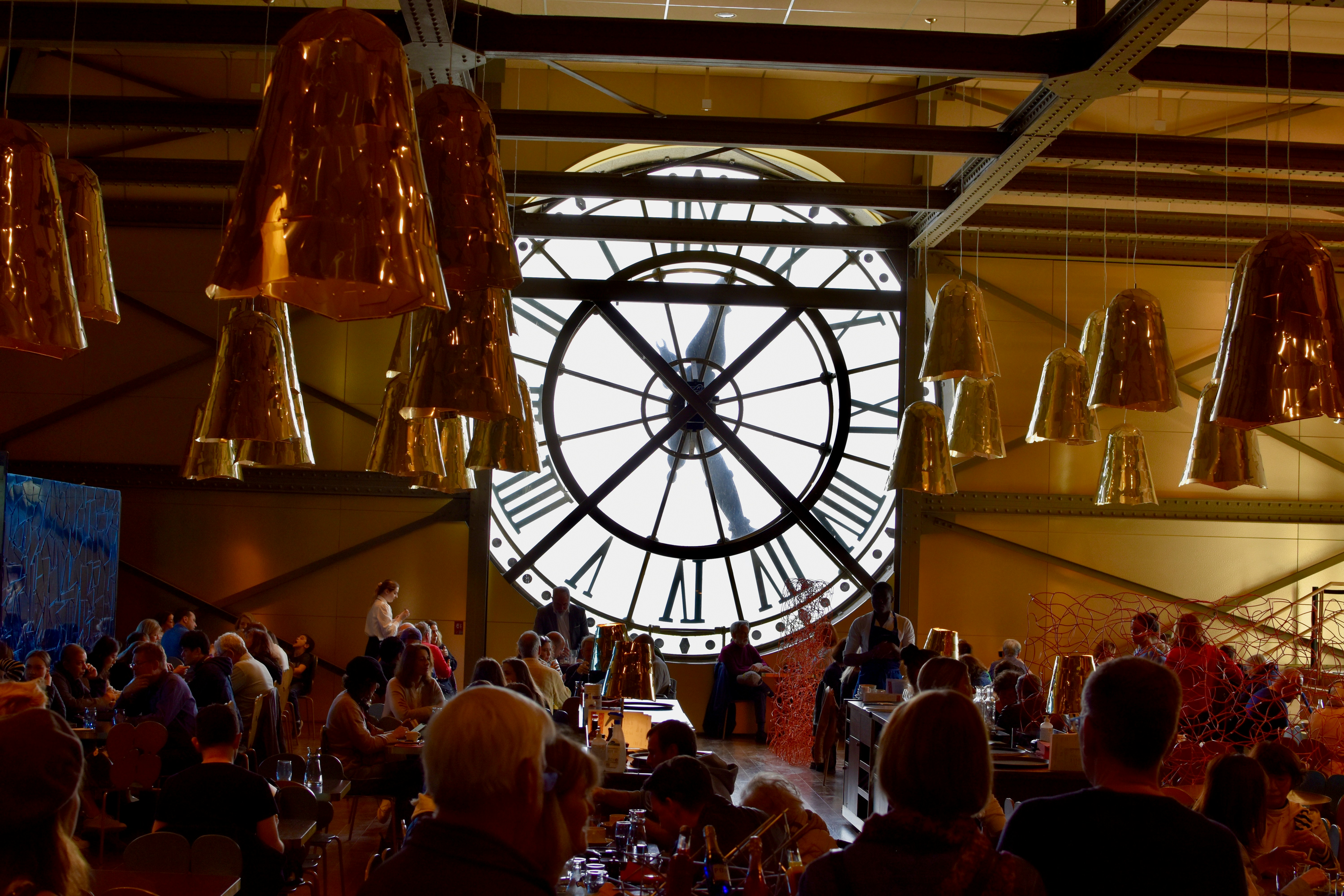 A large clock hanging from the ceiling of a restaurant photo – Free ...