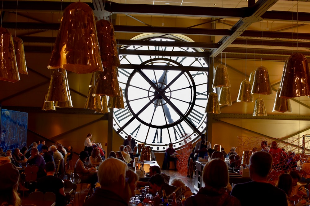 a large clock hanging from the ceiling of a restaurant