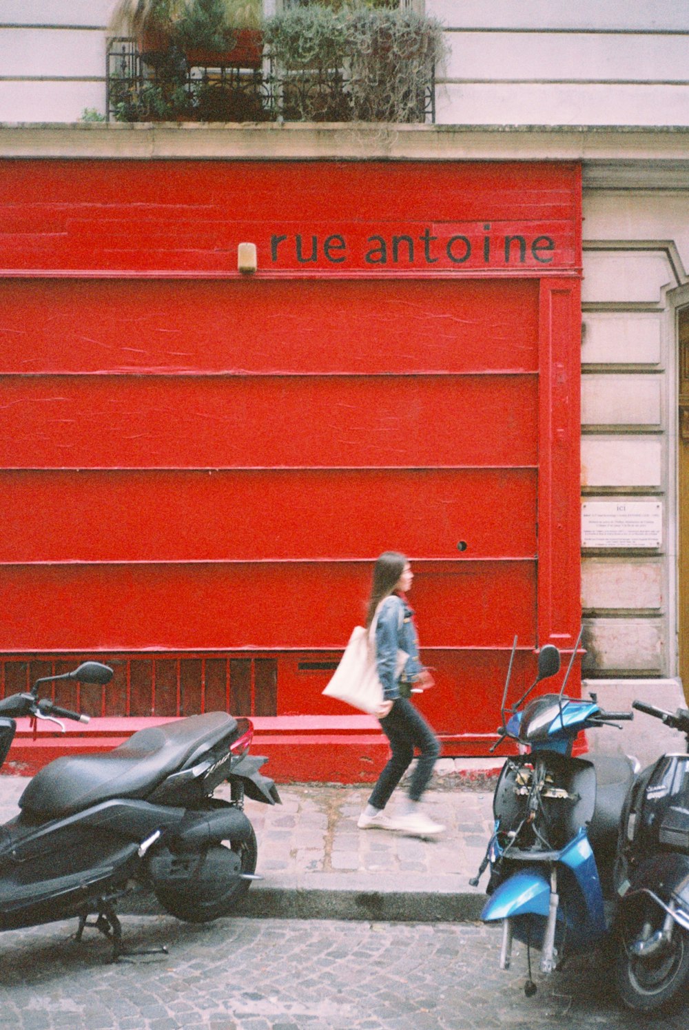 a woman walking past a row of parked scooters