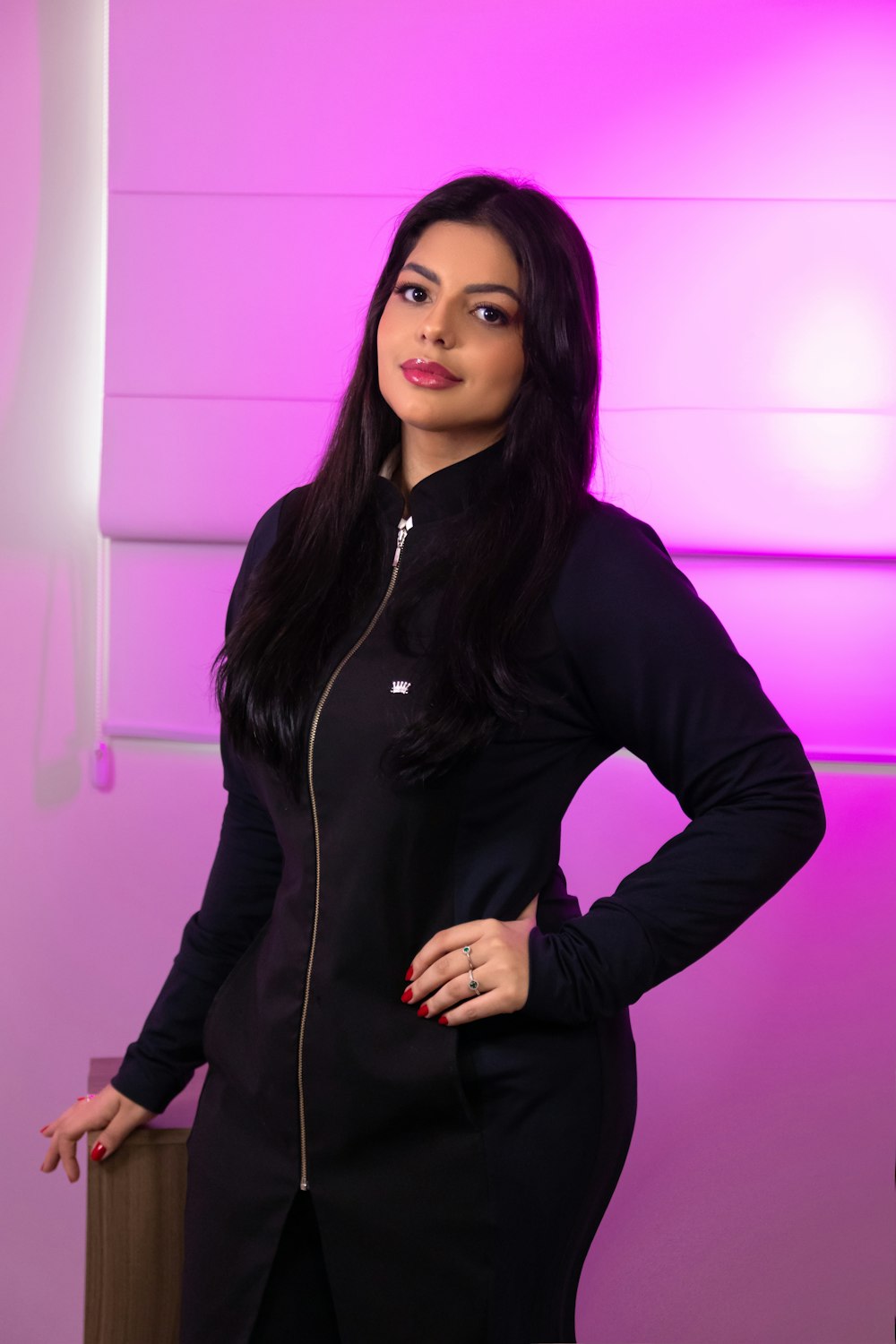 a woman standing in front of a purple wall