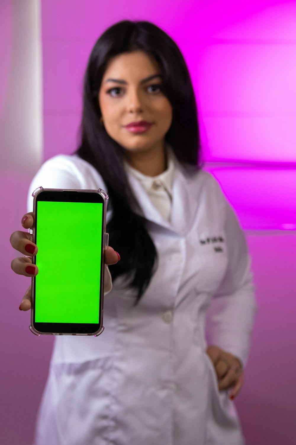 Foto Una mujer con una bata de laboratorio sosteniendo un teléfono celular  con una pantalla verde – Imagen Corporativo gratis en Unsplash